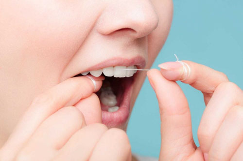 Sử dụng chỉ nha khoa loại bỏ thức ăn dính trong kẽ răng